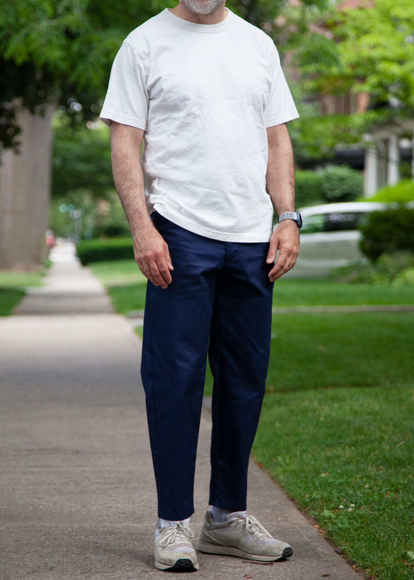 Model wearing white t-shirt, navy lightweight danver pants and white/grey sneakers 