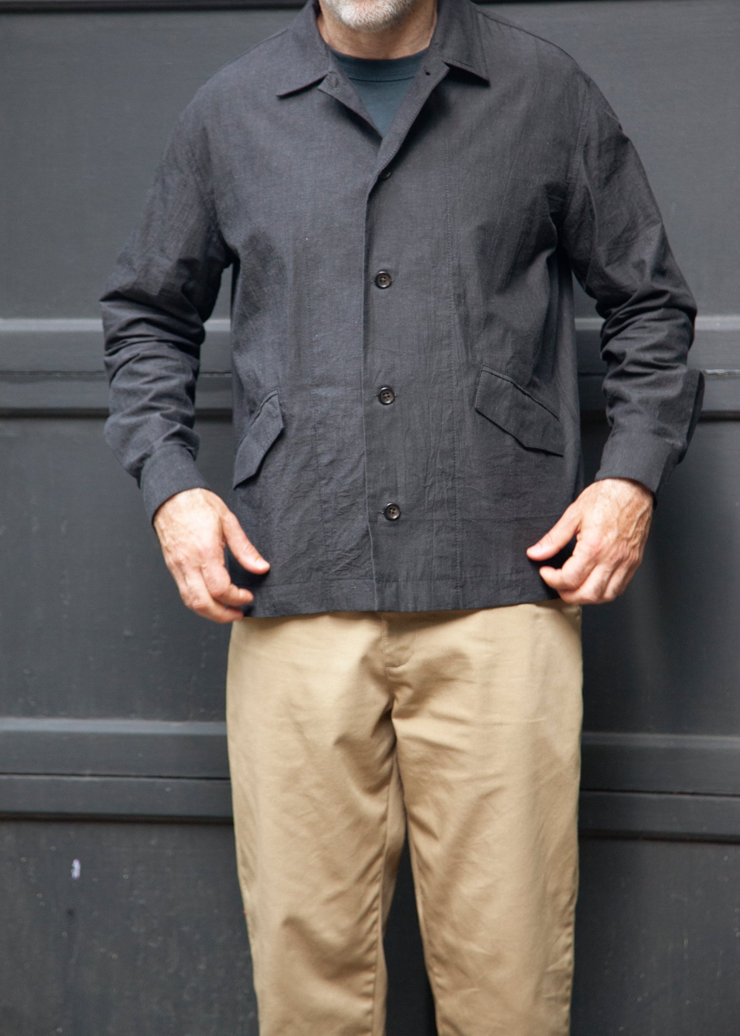 Front Male model wearing the painter shirt unbuttoned in slate grey, khaki pants and grey t-shirt