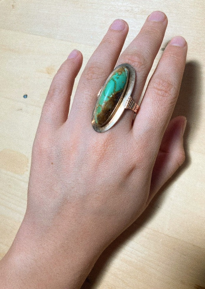 Vintage ring with matrix turquoise front on model hand close up