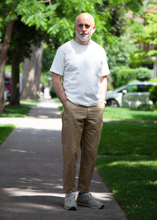 Model wearing white t-shirt, khaki lightweight danver pants and white/grey sneakers