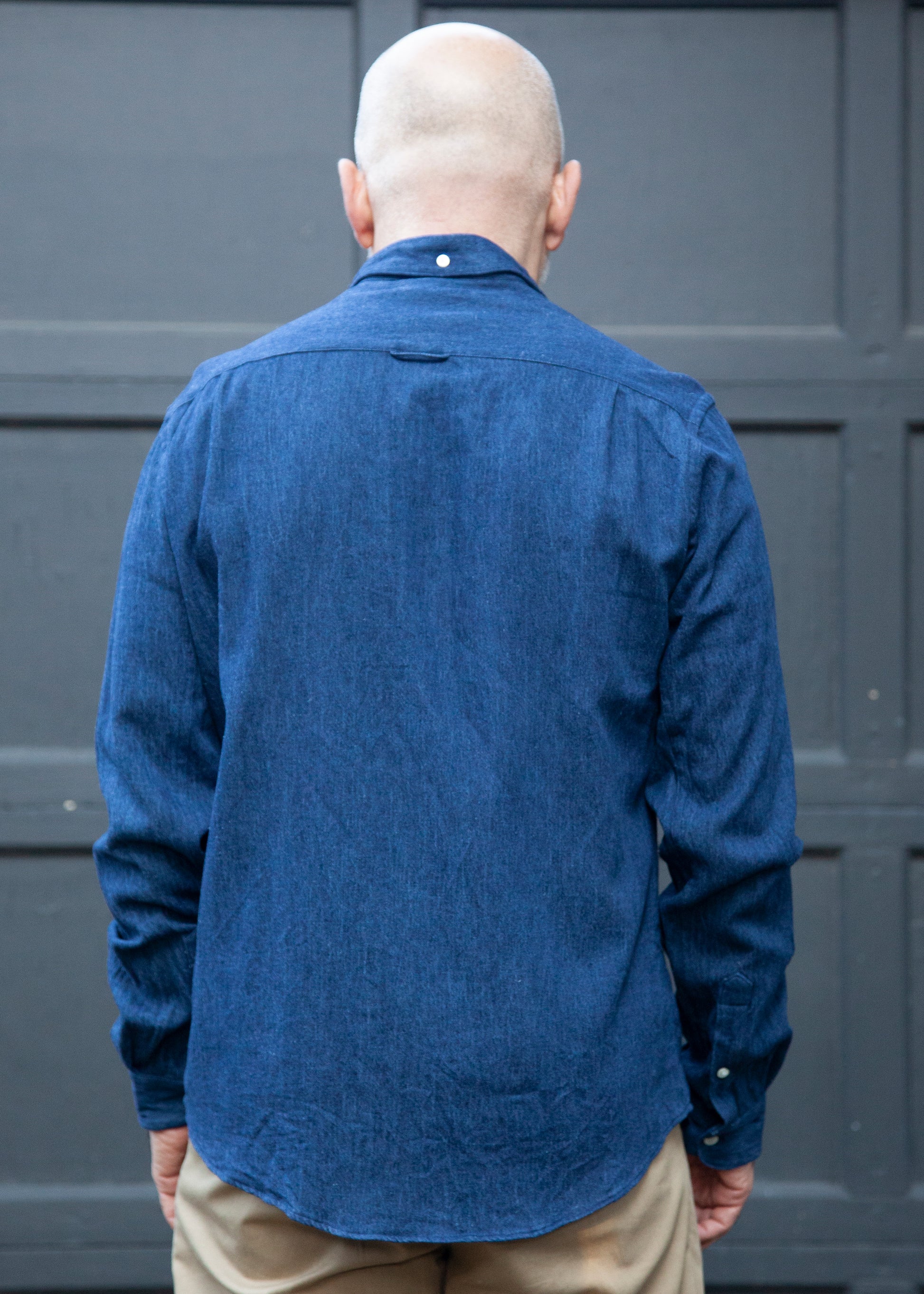 Back shot of model wearing the dark blue denim single needle shirt