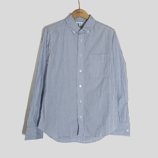 Blue and white striped shirt on a hanger against a gray background