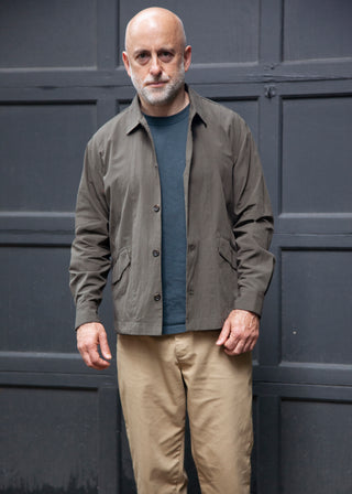 Male model wearing painter shirt in dark green, grey t-shirt and khaki pants