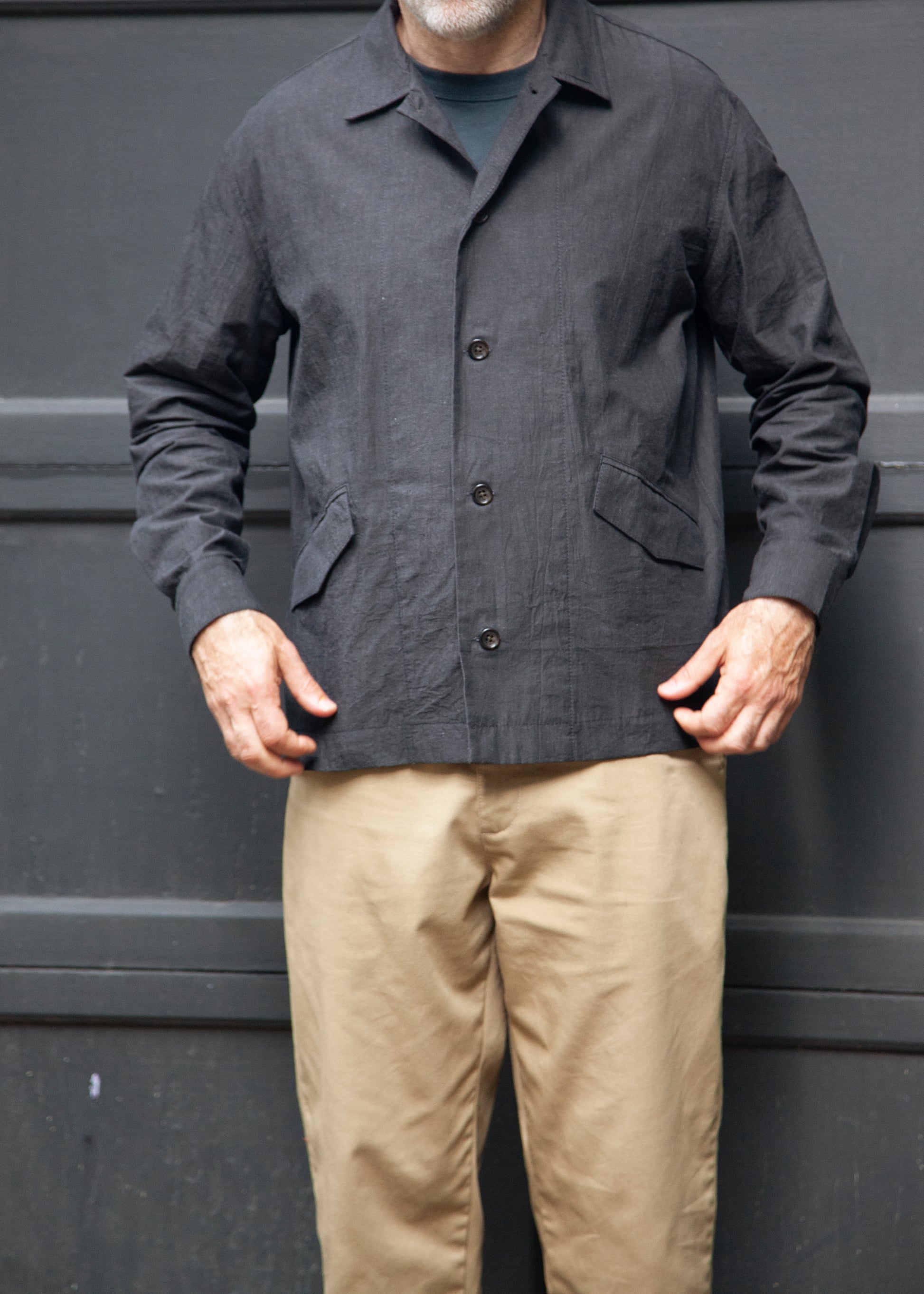 Front Male model wearing the painter shirt unbuttoned in slate grey, khaki pants and grey t-shirt