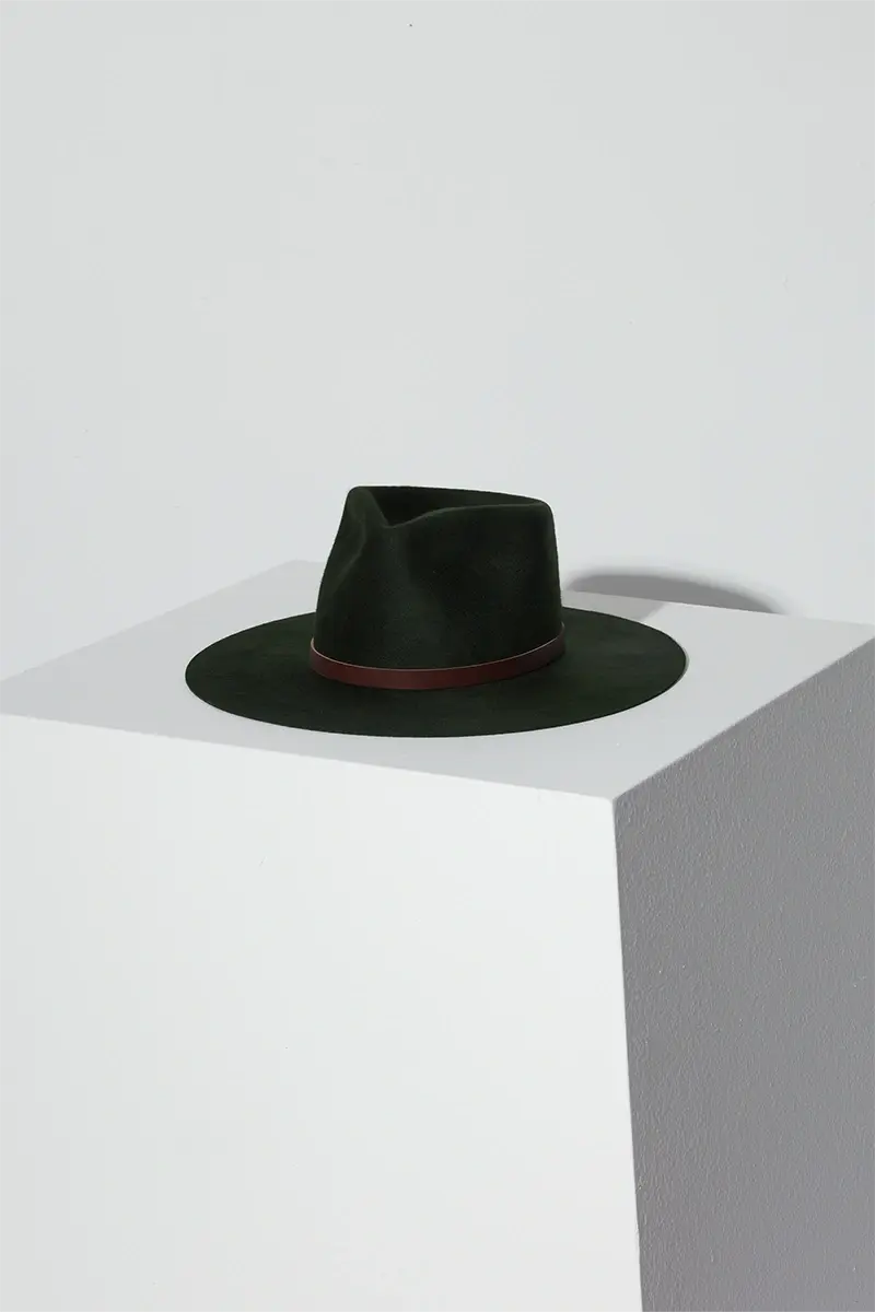 Wynn hat in color deep green on top of white surface