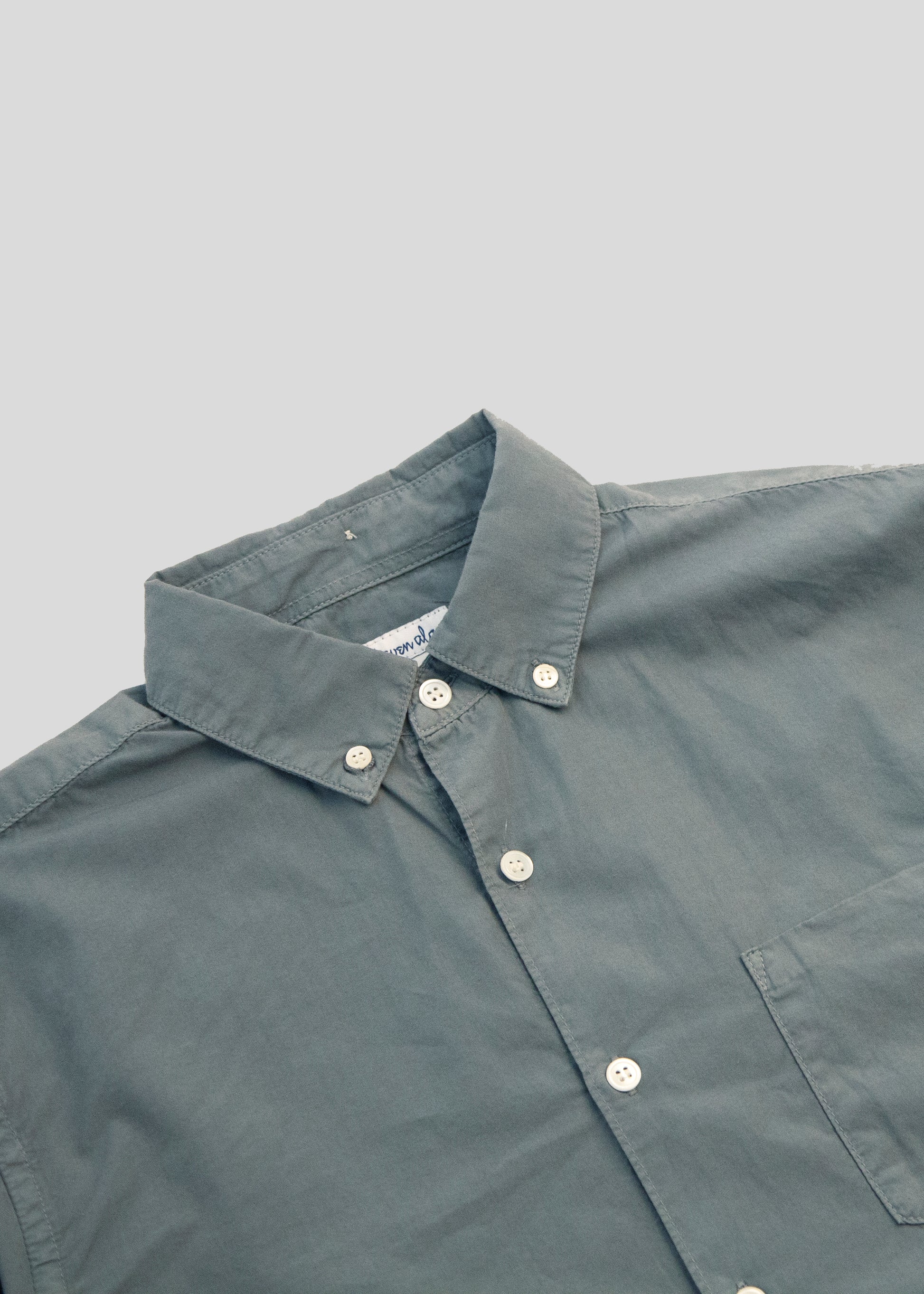 close up front flat lay of washed poplin shirt in steel blue