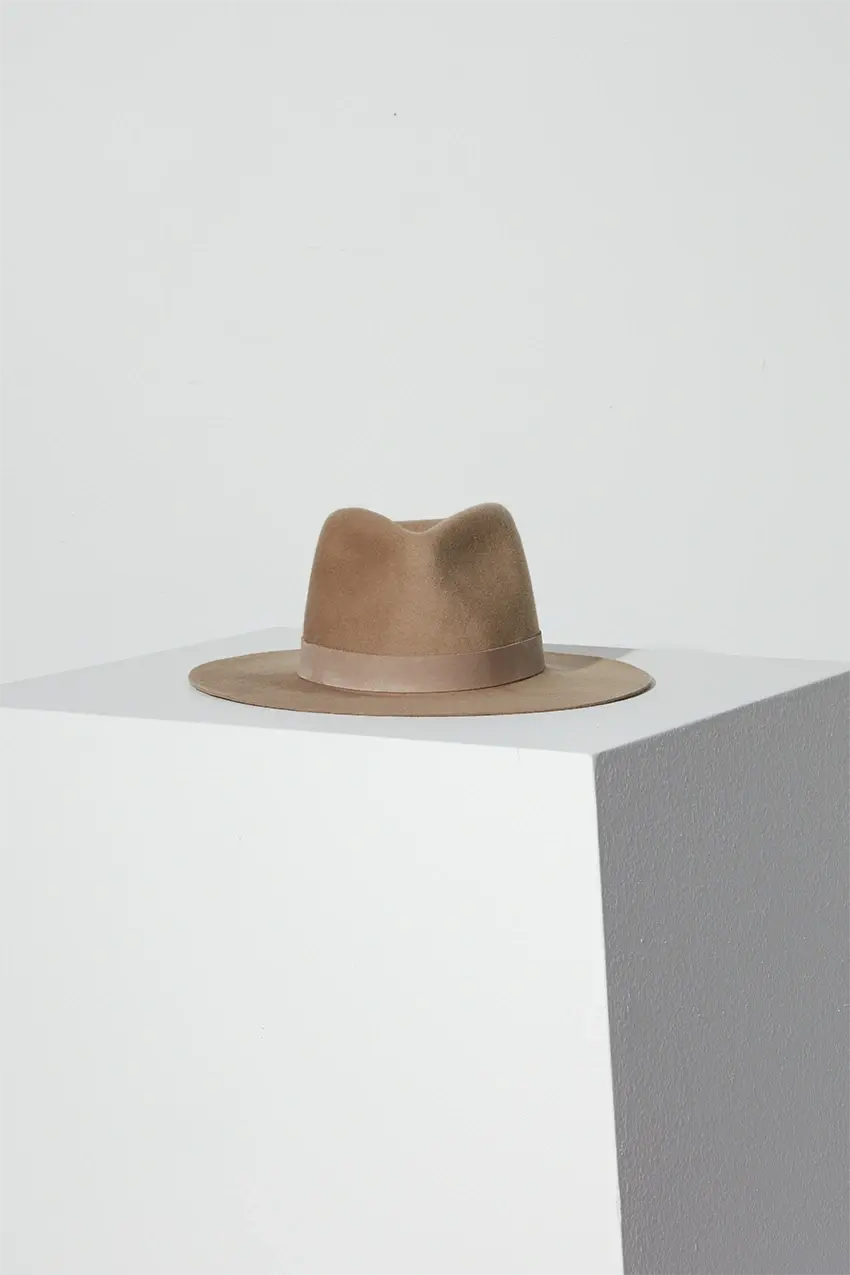 Luca Fedora hat in color wheat on top of a white block
