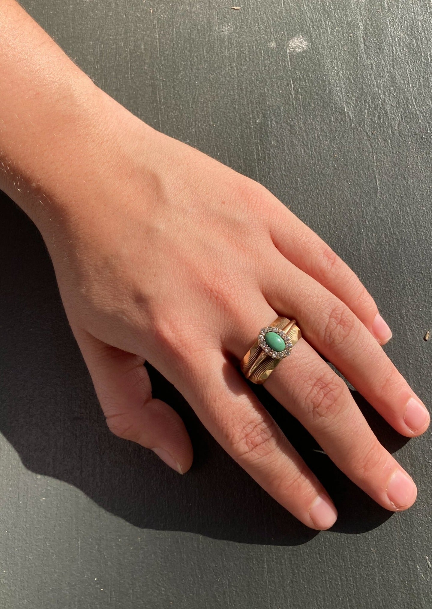 Vintage turquoise and diamond ring on model hand front