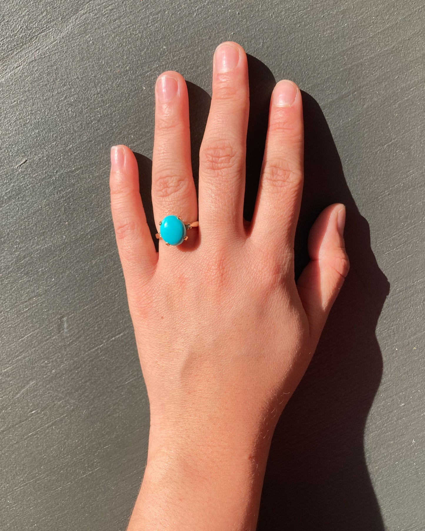 Vintage turquoise and pearl ring on model hand front close up