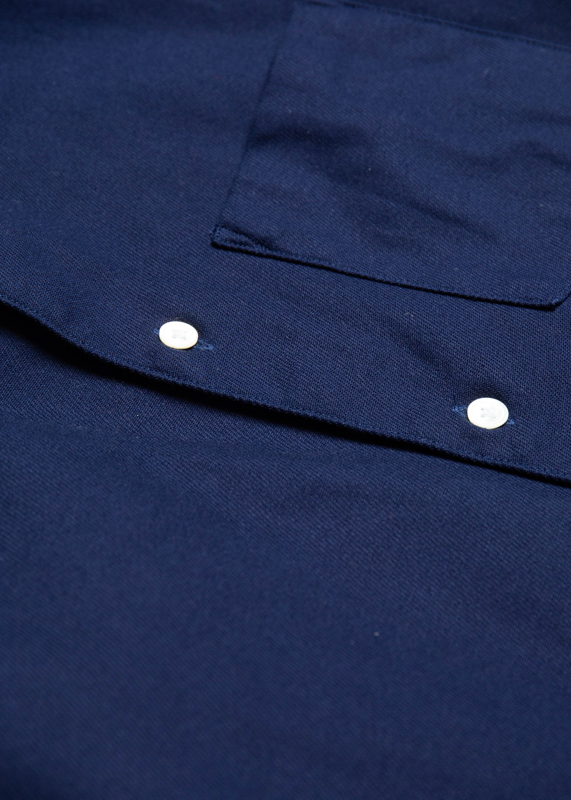 Close up of seams and buttons of single needle shirt in deep navy canvas