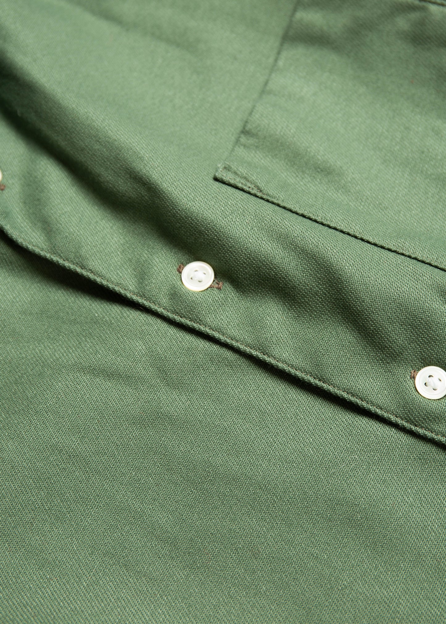 Close up of seams and buttons of the single needle shirt in bottle green canvas 