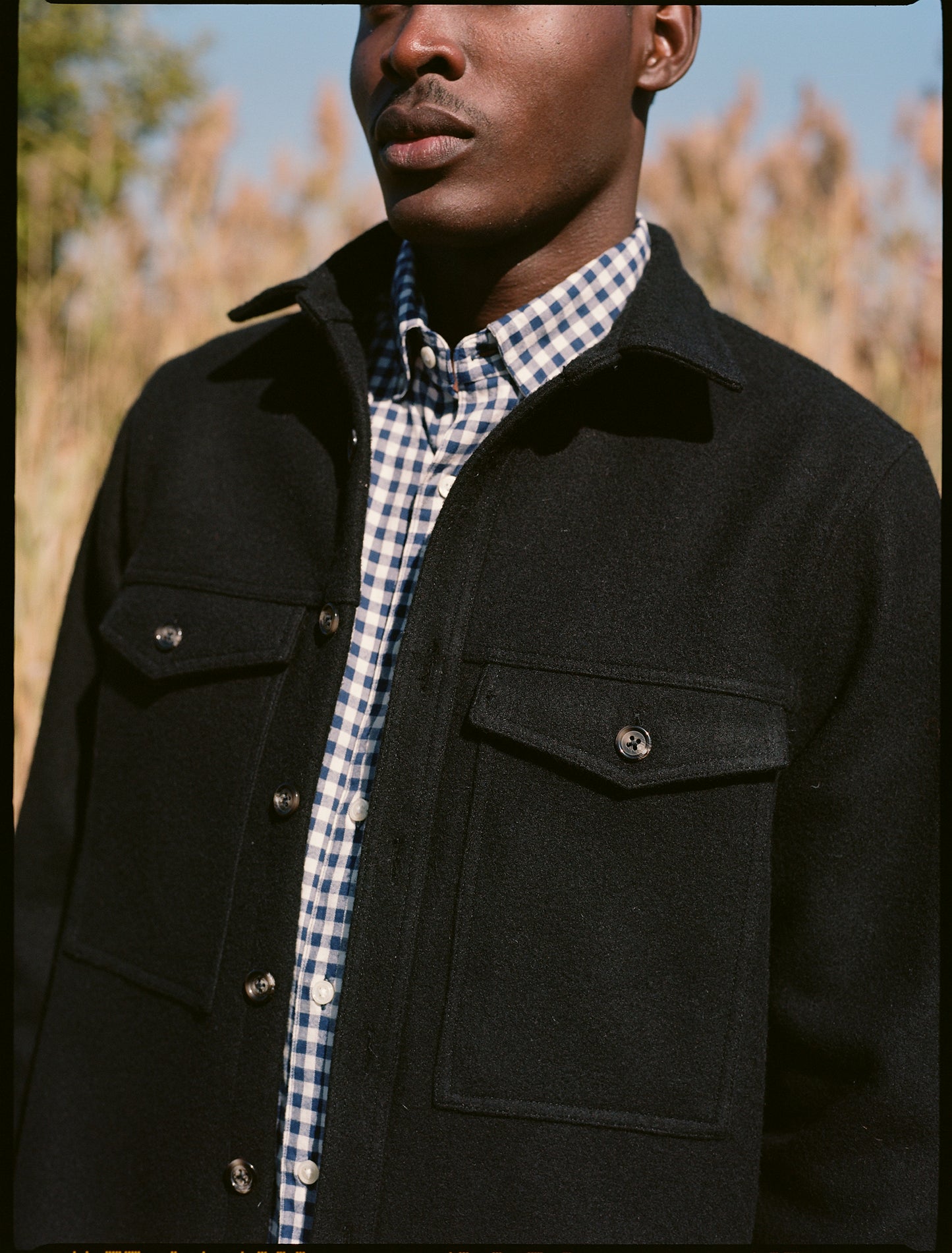 Close up of pockets of the double pocket shirt jacket in color black melton wool on a model