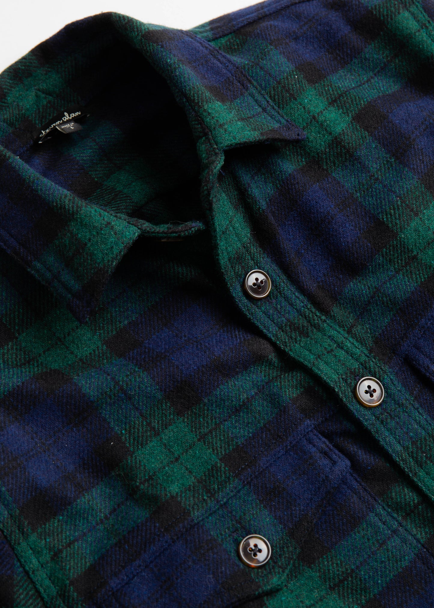 Close up of double pocket shirt jacket in colro blackwatch wool
