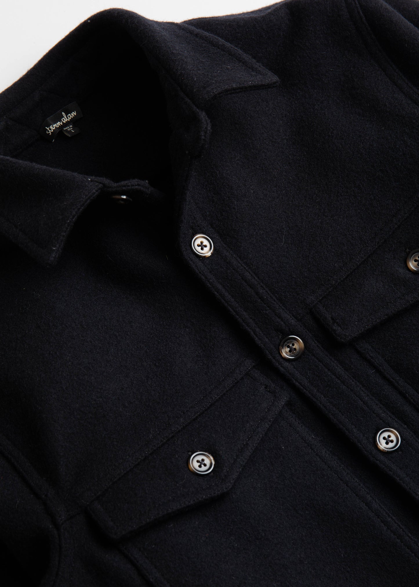 Close up of front flat lay of double pocket shirt jacket in color black melton wool
