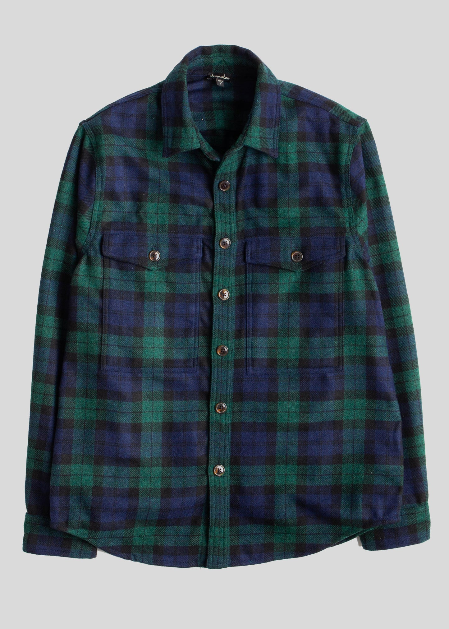 Front flat lay of double pocket shirt jacket in color blackwatch wool